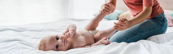 panoramic shot of mother doing massage to infant baby at home  - Φωτογραφία, εικόνα