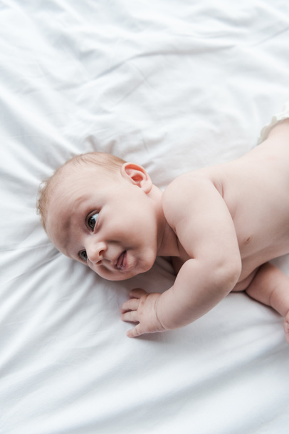 top view of adorable infant baby lying on bed at home  - Foto, Imagen