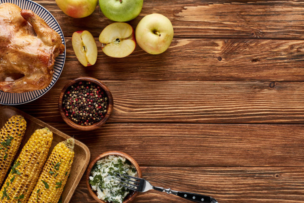 vista superior de pavo asado y maíz a la parrilla con manzanas servidas en mesa de madera
 - Foto, imagen