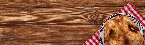 top view of roasted turkey on red plaid napkin served on wooden table, panoramic shot - Fotoğraf, Görsel