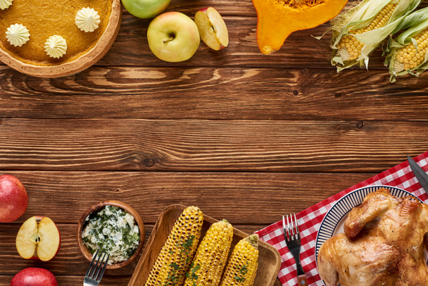 vista superior de pavo asado, pastel de calabaza y verduras a la parrilla servidas en mesa de madera
 - Foto, Imagen