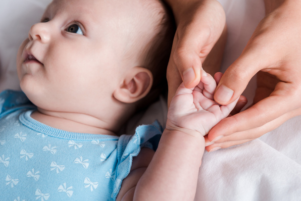 cropped view of mother holding hand of adorable infant  - Photo, image
