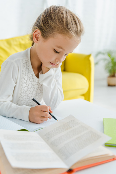 selective focus of cute kid studying at home  - Foto, Bild