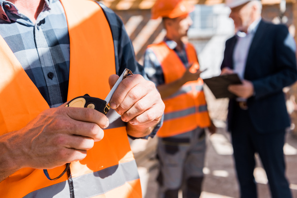 cropped view of constructor holding measuring tape  - Photo, Image