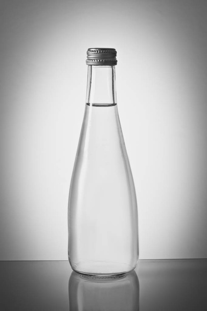 Стеклянная бутылка воды с градиентным фоном - Фото, изображение