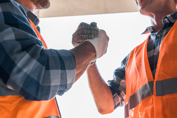 vista recortada del constructor estrechando la mano con su compañero de trabajo
  - Foto, imagen