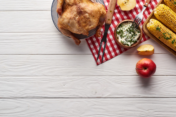 vista superior de pavo y verduras servidas en mesa de madera blanca con servilleta a cuadros para la cena de Acción de Gracias
 - Foto, Imagen