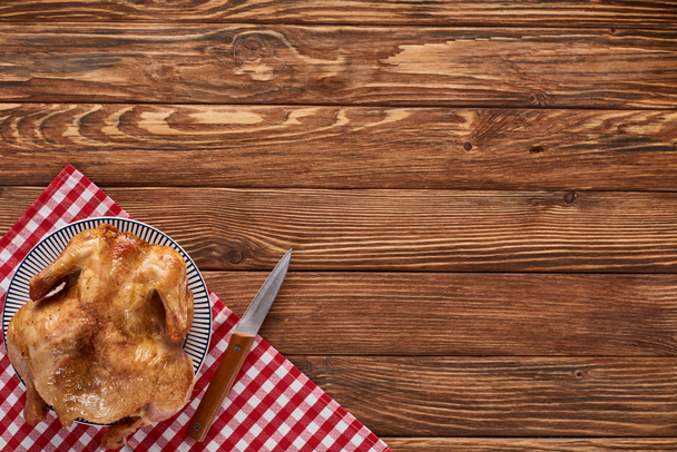vista superior del pavo asado con cuchillo en servilleta a cuadros en la mesa de madera para la cena de Acción de Gracias
 - Foto, Imagen