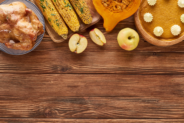 vista superior de torta de abóbora, peru e legumes servidos na mesa de madeira para o jantar de Ação de Graças
 - Foto, Imagem