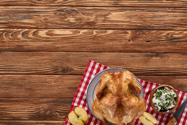 top view of roasted turkey and apples served on napkin at wooden table for Thanksgiving dinner - 写真・画像