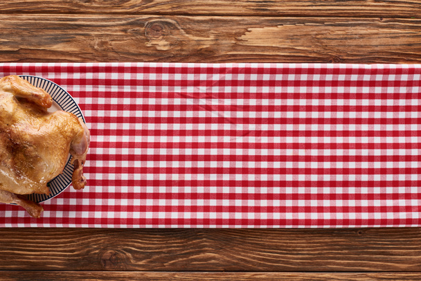 vista superior del pavo asado servido en servilleta a cuadros roja en la mesa de madera para la cena de Acción de Gracias
 - Foto, Imagen