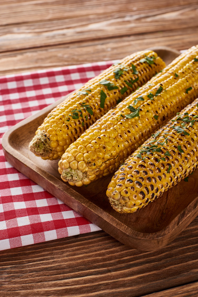 grillowana kukurydza serwowana na czerwonej serwetce w drewnianym stole na kolację dziękczynną - Zdjęcie, obraz