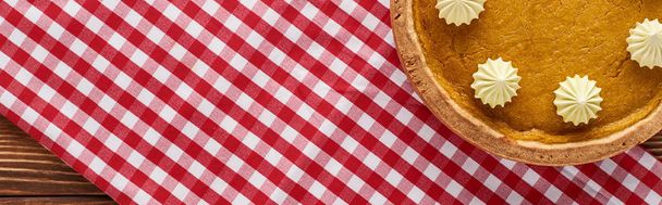 top view of traditional pumpkin pie served at wooden table on red plaid napkin for Thanksgiving dinner, panoramic shot - Fotografie, Obrázek