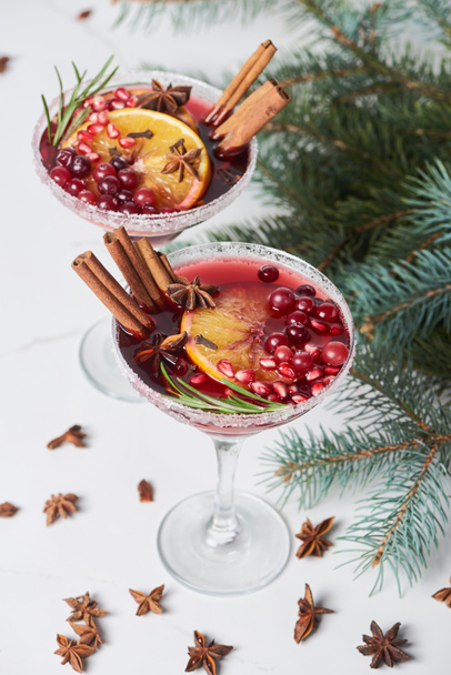selective focus of christmas cocktails with orange, pomegranate and cinnamon - Fotoğraf, Görsel