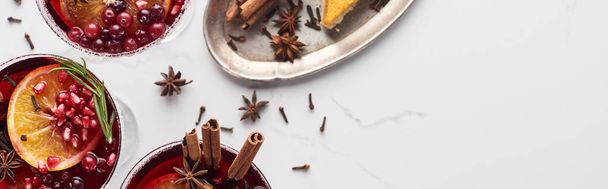 panoramic shot of christmas cocktails with orange, pomegranate, cinnamon - Foto, afbeelding