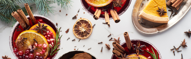 panoramic shot of christmas cocktails with orange, pomegranate, cinnamon and pie on tray  - Foto, afbeelding