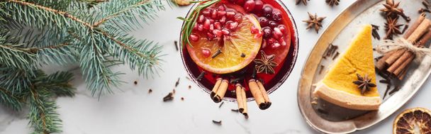 panoramatický záběr vánočního koktejlu s pomerančem, granátovým jablkem, skořicí a koláčem na tácu  - Fotografie, Obrázek