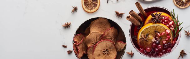 panoramic shot of christmas cocktail with orange, pomegranate, cinnamon and dry apples  - Foto, Bild