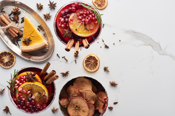 top view of christmas cocktails with orange, pomegranate, cinnamon, pie on tray, dry apples  - Foto, immagini