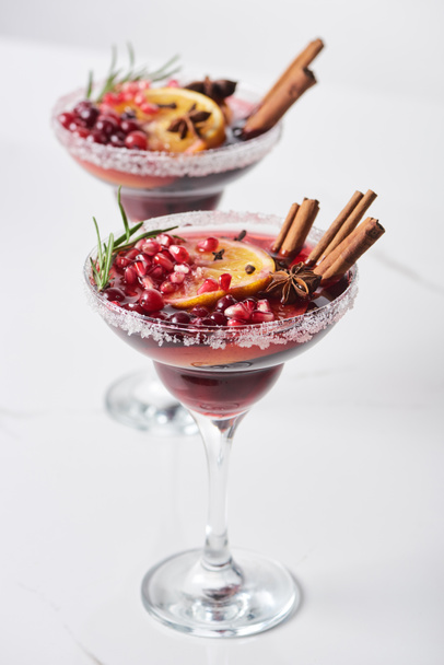 selective focus of christmas cocktail with orange, pomegranate, cinnamon - Foto, imagen