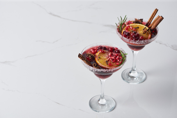 christmas cocktail with orange, pomegranate, cinnamon on marble table  - Photo, Image