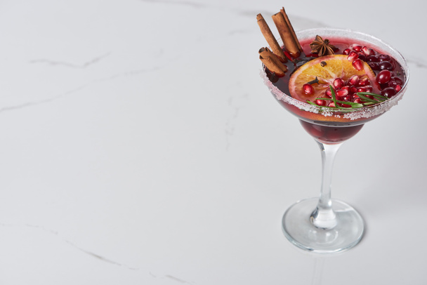 christmas cocktail with orange, pomegranate, cinnamon on marble table  - 写真・画像