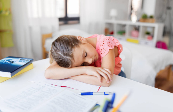 tired student girl sleeping on table at home - 写真・画像