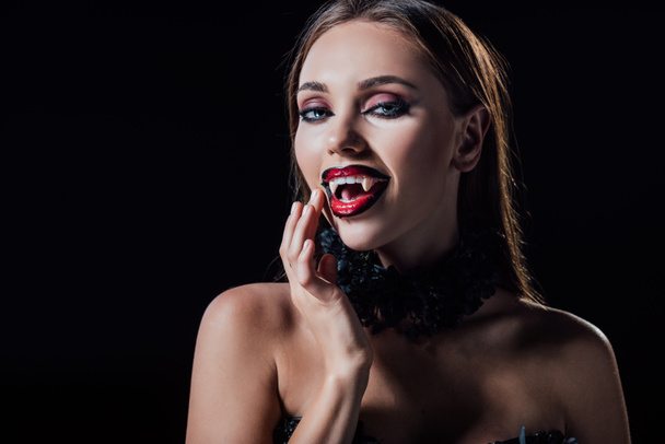 naked scary vampire girl showing fangs isolated on black - Foto, Imagem