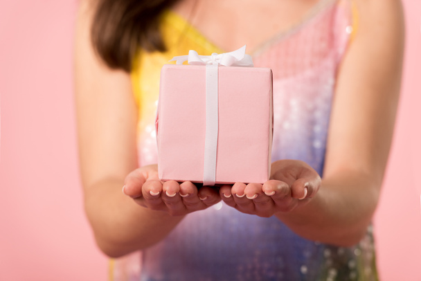 partial view of girl holding gift box isolated on pink - 写真・画像