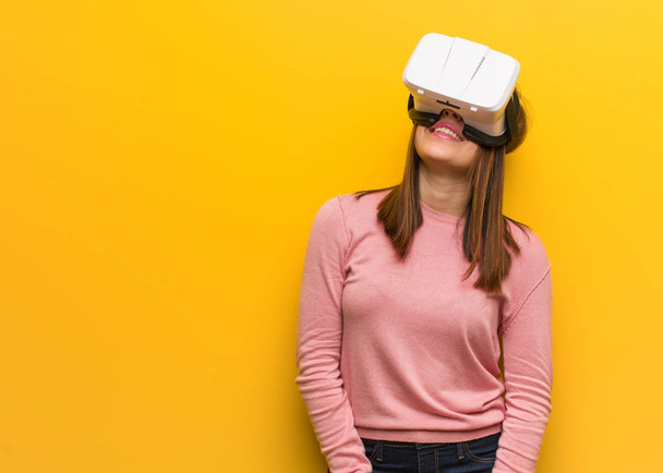junge süße Frau trägt eine Virtual-Reality-Brille fröhlich mit einem breiten Lächeln - Foto, Bild