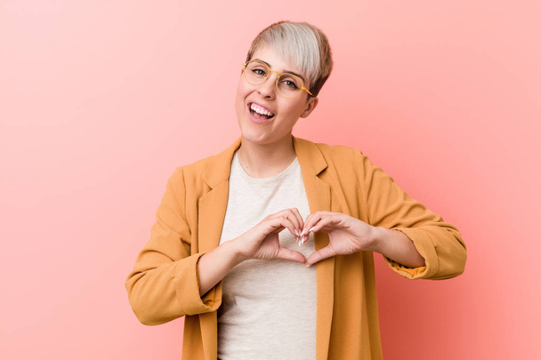 Young caucasian woman wearing a casual business clothes smiling and showing a heart shape with hands. - Foto, afbeelding