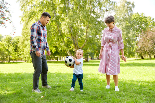 happy family playing soccer at summer park - Fotó, kép