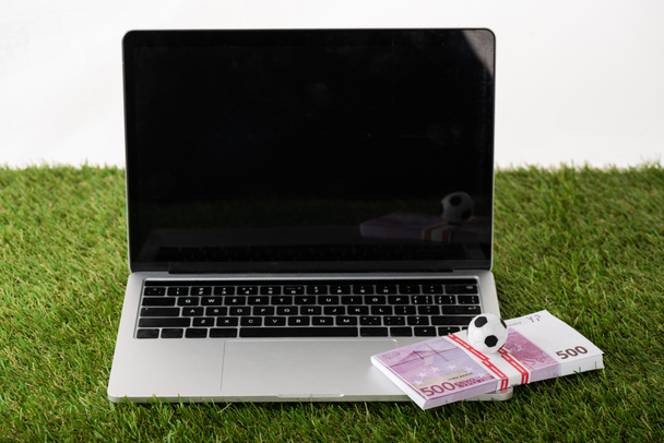 bola de futebol de brinquedo e notas de euro no laptop com tela em branco na grama verde isolada no branco, conceito de apostas esportivas
 - Foto, Imagem