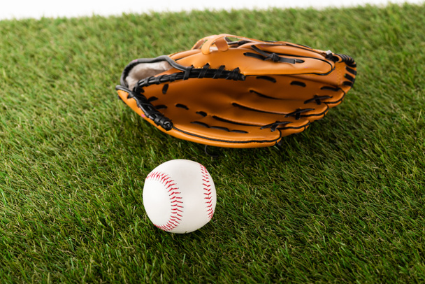 baseball glove and ball on green grass isolated on white, sports betting concept - 写真・画像