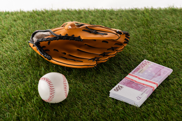 baseball glove and ball near euro banknotes on green grass isolated on white, sports betting concept - Фото, зображення