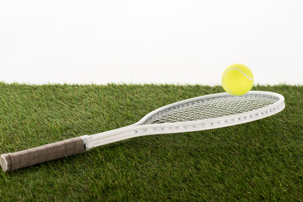 Tennisschläger und Ball auf grünem Rasen isoliert auf weißem, Sportwetten-Konzept - Foto, Bild