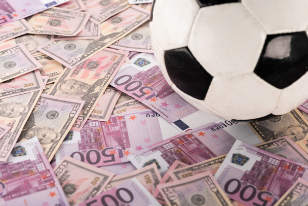 close up view of soccer ball on euro and dollar banknotes, sports betting concept - Foto, Imagem