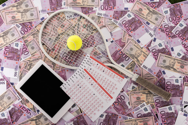 vista superior de la tableta digital, listas de apuestas, raqueta de tenis y pelota en euros y billetes de dólar, concepto de apuestas deportivas
 - Foto, Imagen