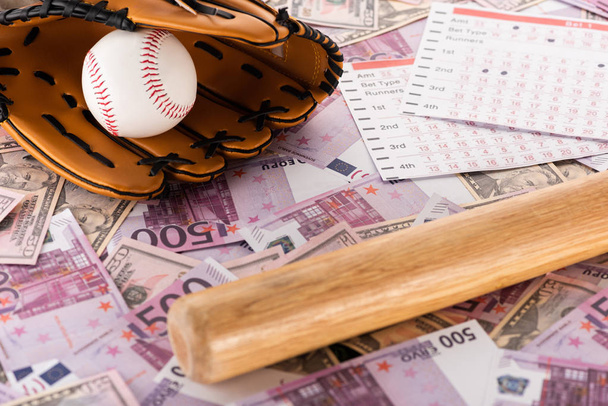 betting lists near baseball bat, glove and ball on euro and dollar banknotes, sports betting concept - Fotoğraf, Görsel
