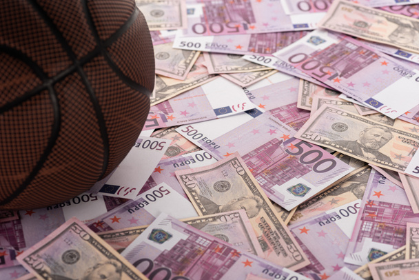 close up view of basketball ball on euro and dollar banknotes, sports betting concept - Zdjęcie, obraz