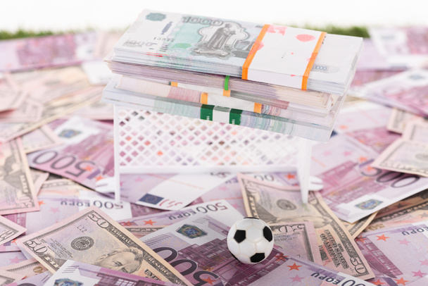 pelota de fútbol en miniatura y puertas cerca de paquetes de dinero en euros y billetes de dólar aislados en blanco, concepto de apuestas deportivas
 - Foto, Imagen