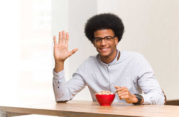 Jonge zwarte man met een ontbijt dat nummer vijf weergeeft - Foto, afbeelding