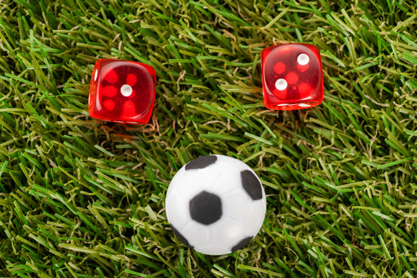 dice and toy soccer ball on green grass, sports betting concept - Photo, Image