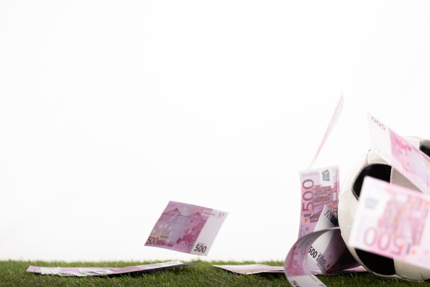 balón de fútbol cerca de billetes en euros voladores aislados en blanco, concepto de apuestas deportivas
 - Foto, imagen