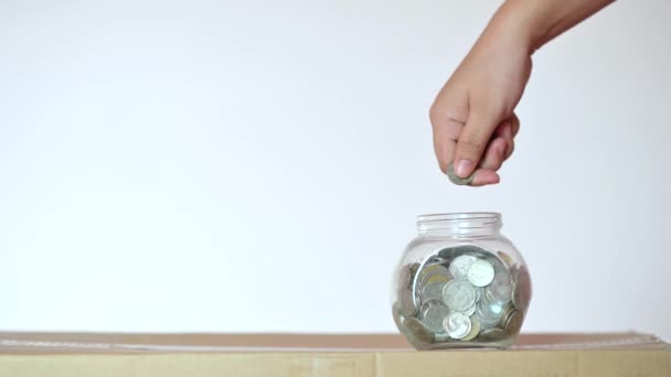 Uomo d'affari mettere una moneta in un concetto bottiglia di vetro di risparmiare denaro e investire in attività finanziarie. video 4K
 - Filmati, video
