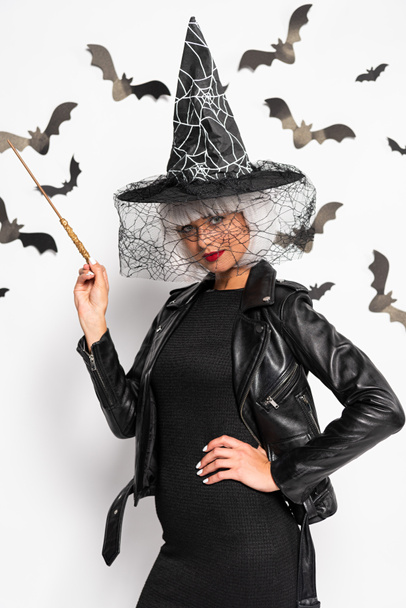 attractive woman in witch hat and wig holding magic wand in Halloween - Photo, Image