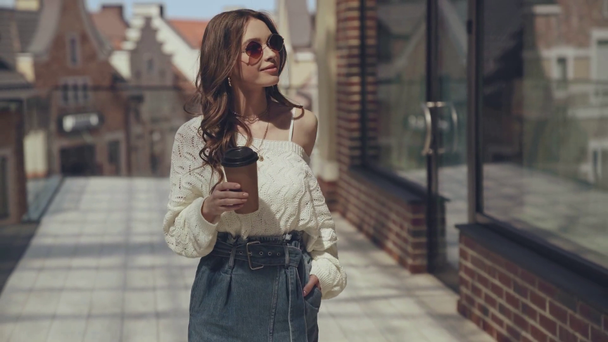 attractive woman walking and holding paper cup - Imágenes, Vídeo