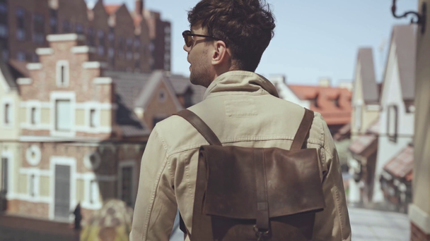 przystojny mężczyzna z plecakiem spacery na zewnątrz  - Materiał filmowy, wideo