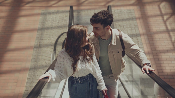 happy man and woman on escalator  - Záběry, video