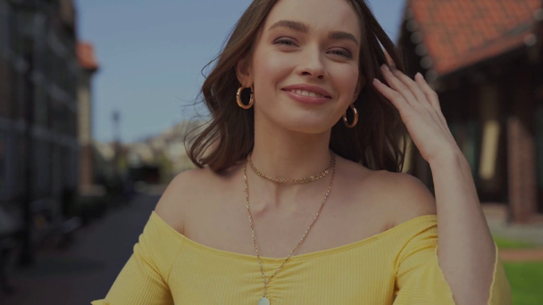 cheerful girl smiling while touching hair  - Video, Çekim